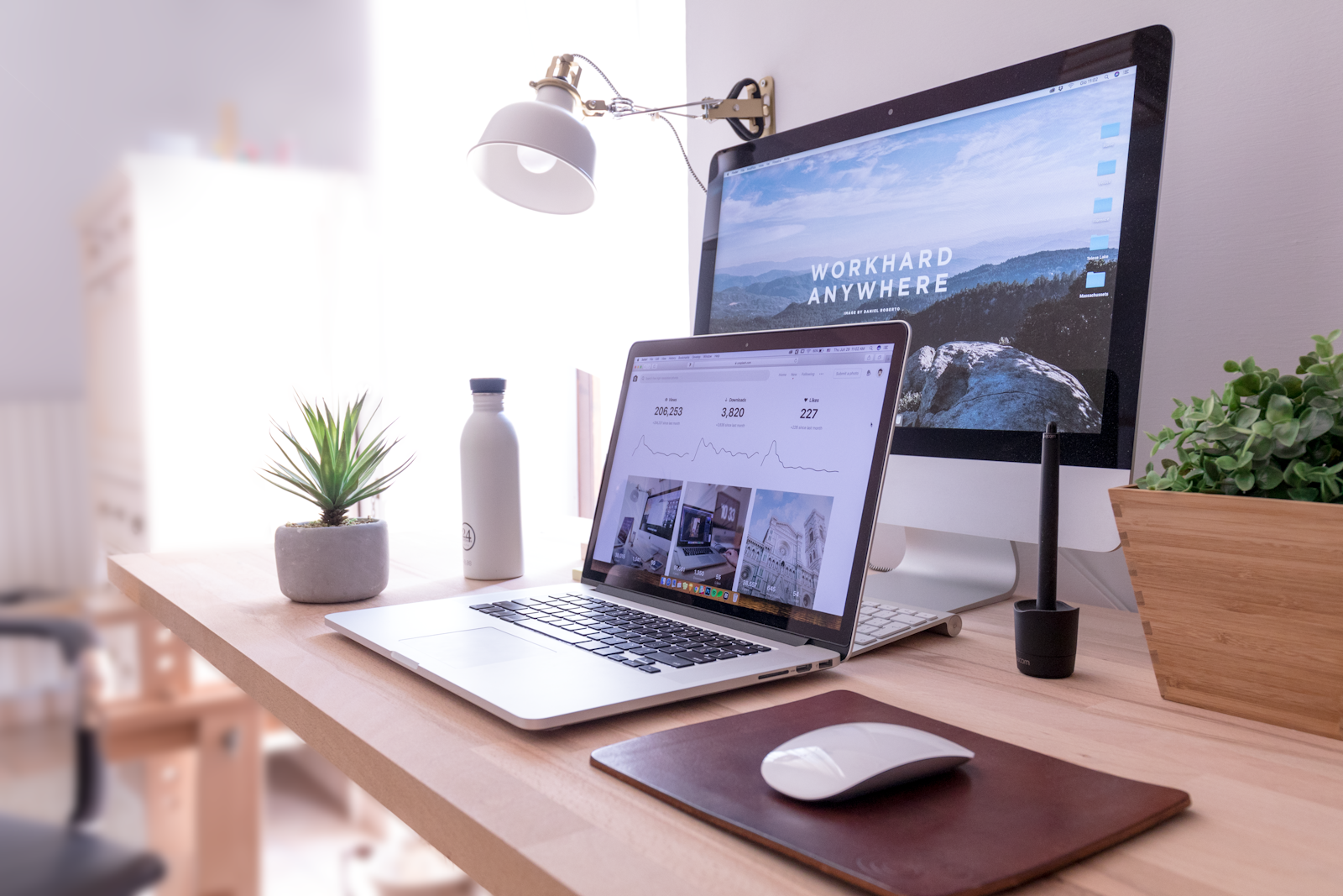 A bright creative workspace with a desktop computer and notebook